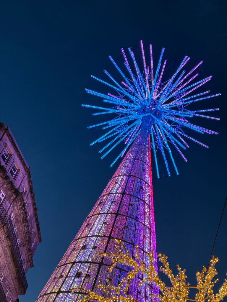 Vibrant LED Christmas tree in Vigo, Spain against a night sky.